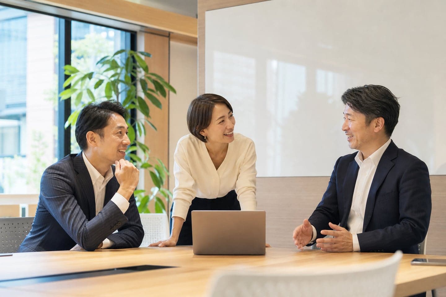 明るい会議室で議論するチーム